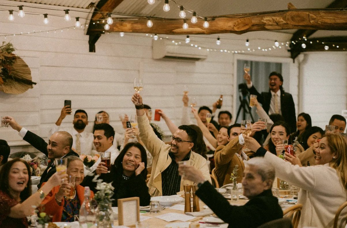 A seated wedding reception in the Carrington Room with greenery on the beams
