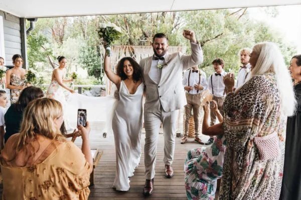 A couple entering along the deck to cheering guests