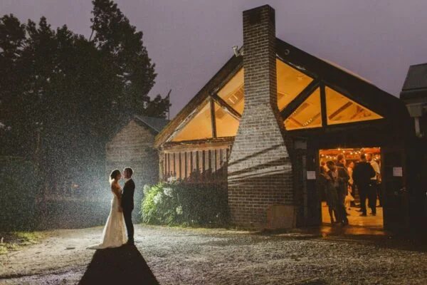 A couple outside the glowing Carrington Room at night