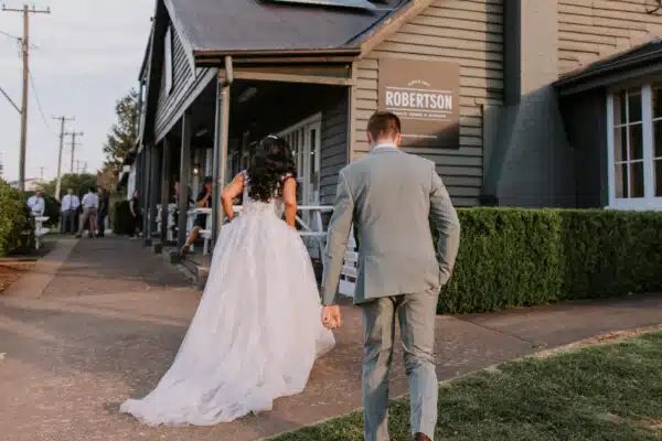 A couple walking to the pub&rsquo;s front door past the Robertson sign